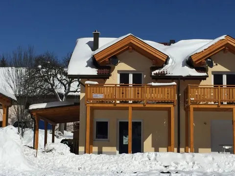 Seitenansicht des Hauses mit Balkon im Schnee