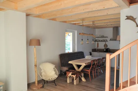 Essbereich mit Holztisch und offener Küche im Hintergrund