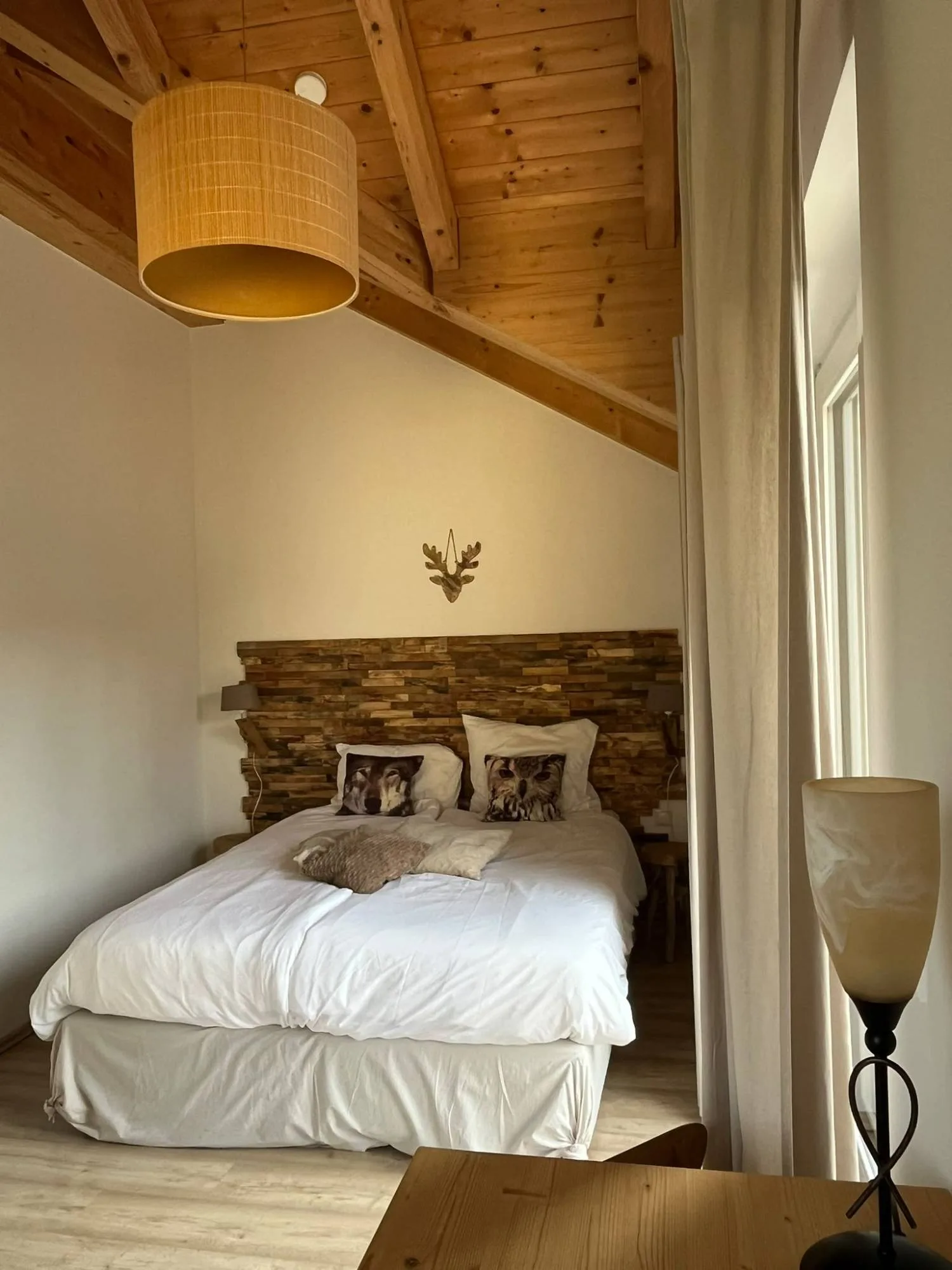 Tweepersoonsbed met houten wandpaneel in slaapkamer 1
