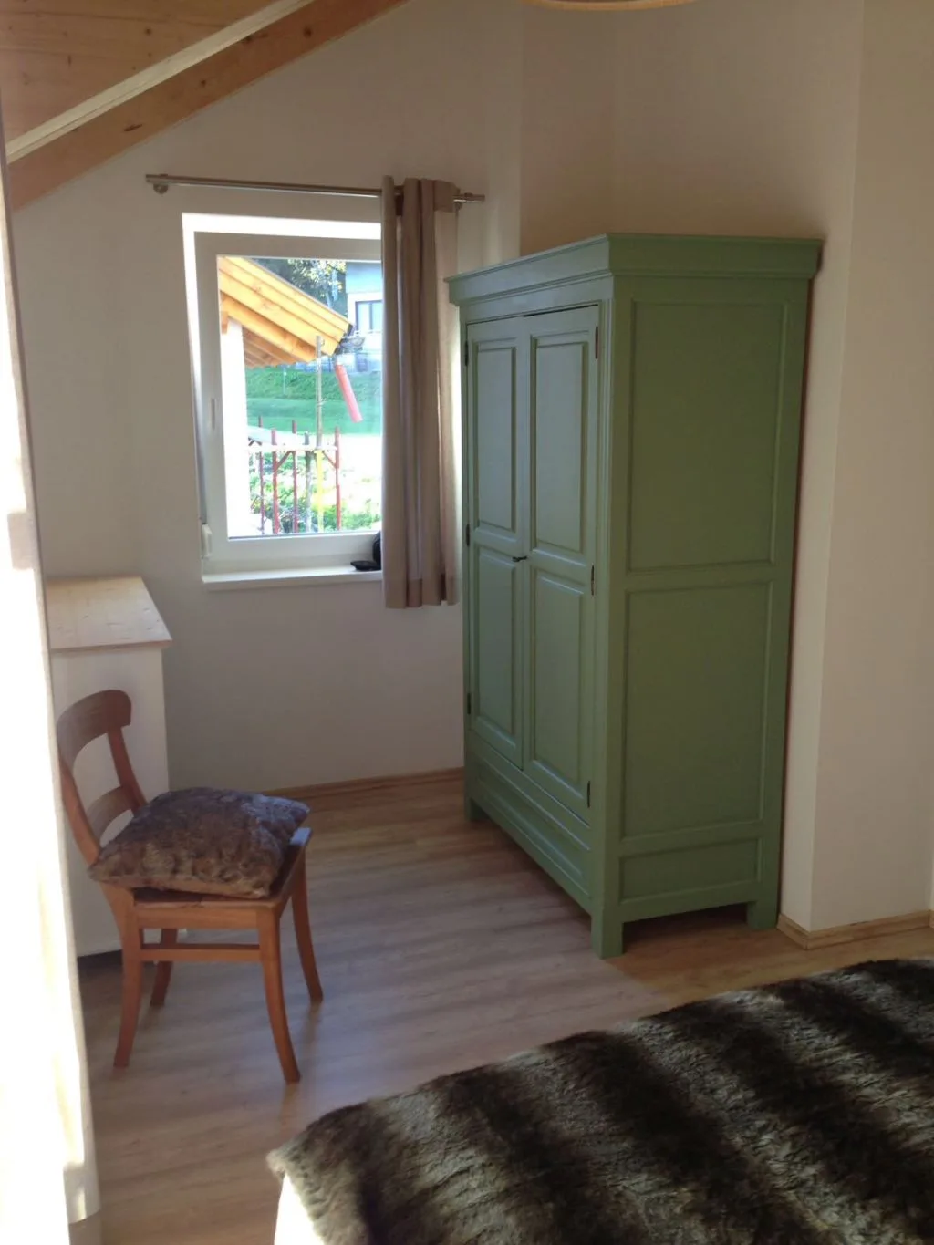 Schlafzimmer mit Holzschrank und Dachfenster
