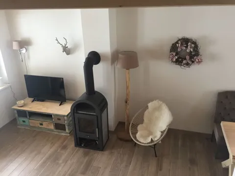 Wohnzimmer mit Holzofen und Fernseher