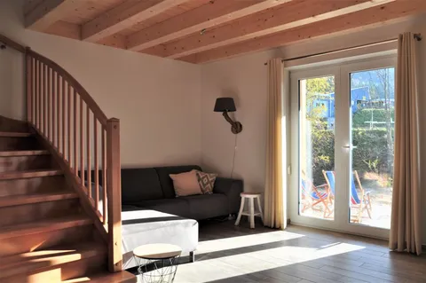 Sitzecke mit Sofa und Flügeltüren zur Terrasse